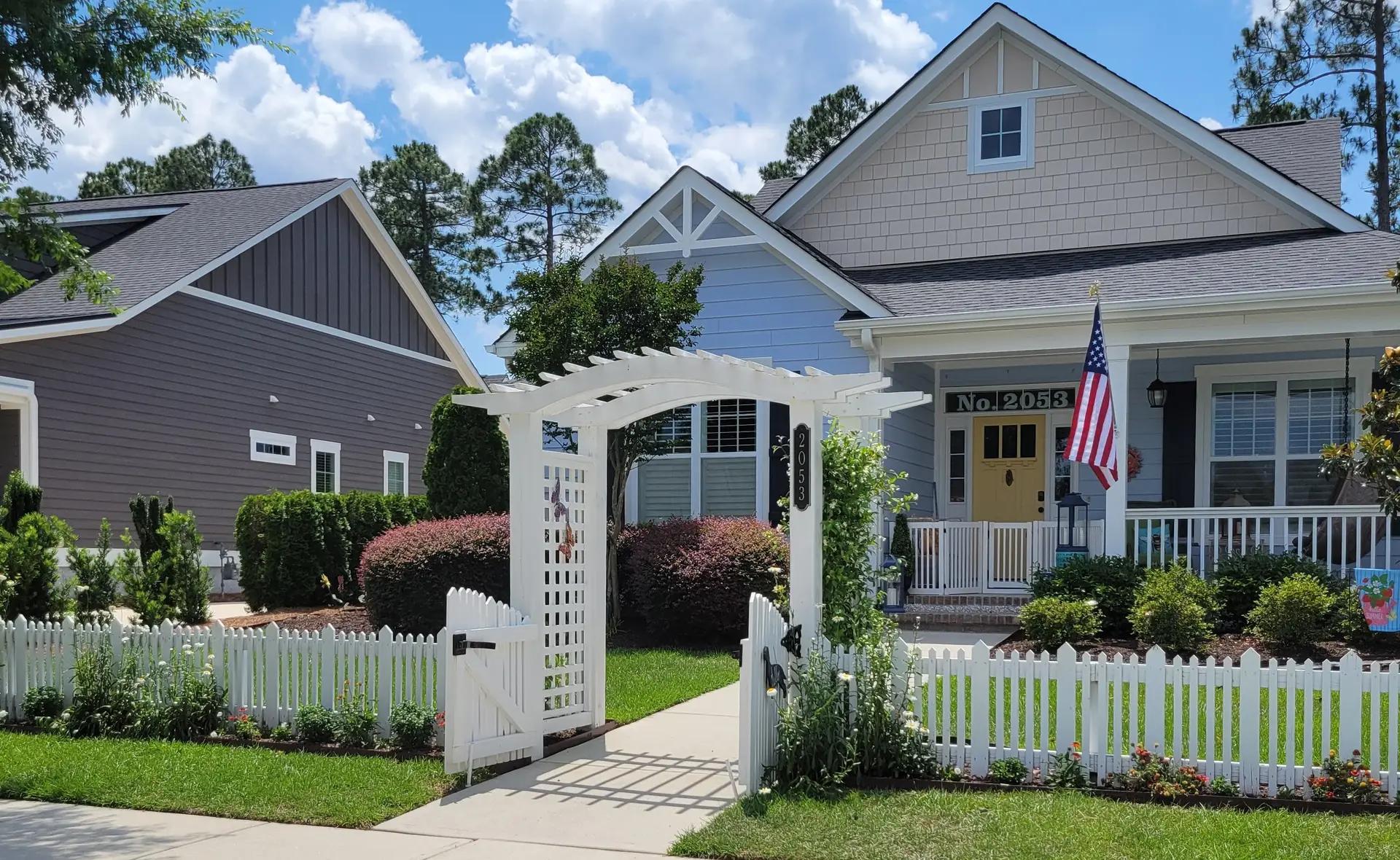 White wooden arbor with classic picket fence entry